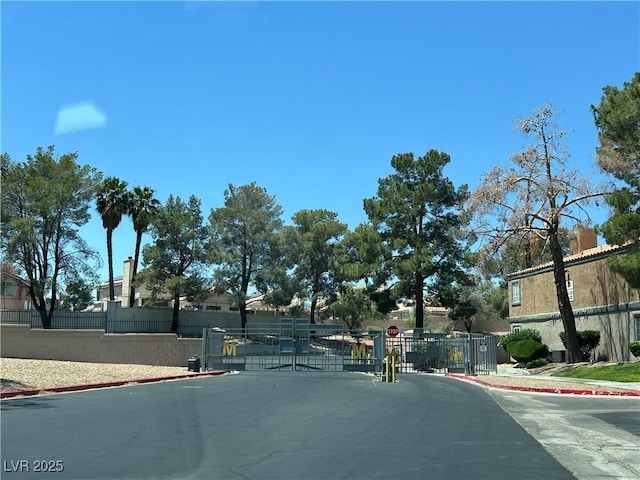 5260 Mission Monterey Ln Unit 208, Las Vegas, NV 89107 - view of asphalt street with a gate, sidewalks, curbs, and a gated entry