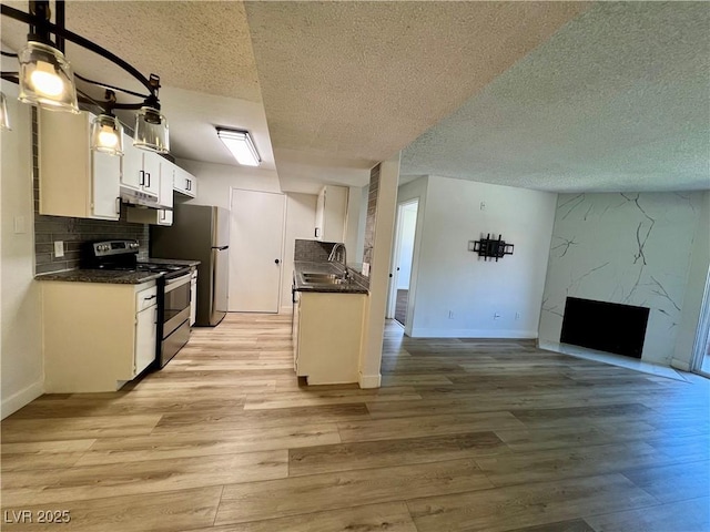 5260 Mission Monterey Ln Unit 208, Las Vegas, NV 89107 - kitchen with range, dark countertops, a textured ceiling, open floor plan, and light wood finished floors