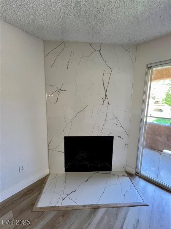 5260 Mission Monterey Ln Unit 208, Las Vegas, NV 89107 - detailed view of a high end fireplace, a textured ceiling, wood finished floors, and baseboards