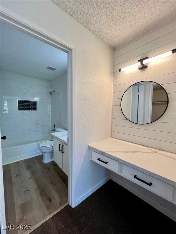 5260 Mission Monterey Ln Unit 208, Las Vegas, NV 89107 - bathroom with vanity, toilet, wood finished floors, a textured ceiling, and shower / washtub combination