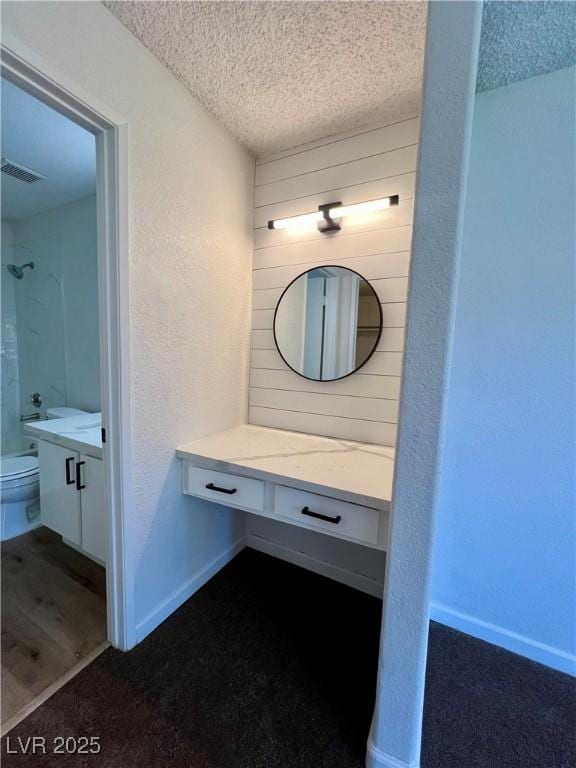5260 Mission Monterey Ln Unit 208, Las Vegas, NV 89107 - bathroom featuring vanity, toilet, a textured ceiling, a shower, and a textured wall