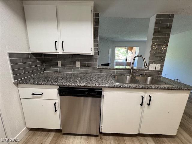 5260 Mission Monterey Ln Unit 208, Las Vegas, NV 89107 - kitchen featuring dishwasher, a sink, light wood-type flooring, white cabinetry, and decorative backsplash