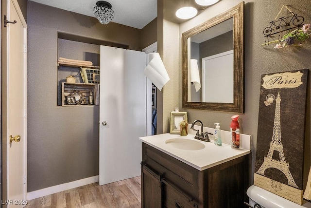 8884 Perfect Diamond Ct, Las Vegas, NV 89129 - bathroom with vanity, toilet, wood finished floors, a textured wall, and baseboards