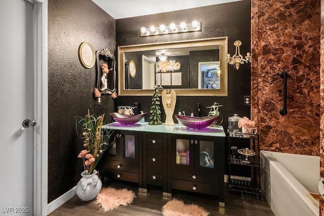 8884 Perfect Diamond Ct, Las Vegas, NV 89129 - full bathroom featuring wood finished floors, double vanity, a textured wall, and a tub to relax in