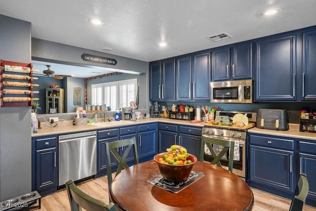 8884 Perfect Diamond Ct, Las Vegas, NV 89129 - kitchen with stainless steel appliances, a sink, blue cabinets, light countertops, and recessed lighting