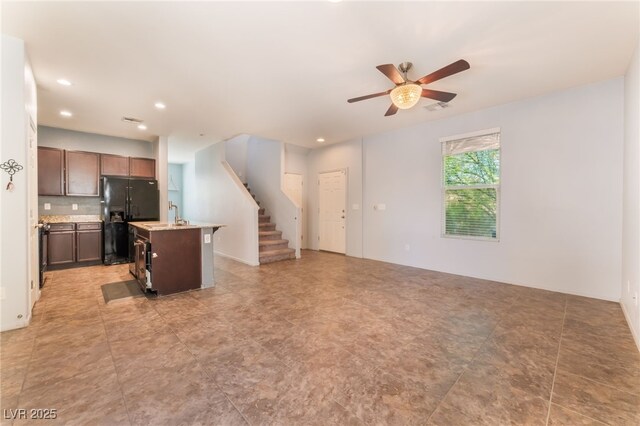 4610 Lime Straight Dr, Las Vegas, NV 89115 - kitchen with black refrigerator with ice dispenser, a ceiling fan, open floor plan, an island with sink, and recessed lighting
