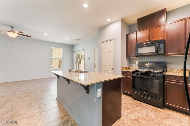 4610 Lime Straight Dr, Las Vegas, NV 89115 - kitchen featuring black appliances, a sink, a ceiling fan, light stone counters, and a center island with sink