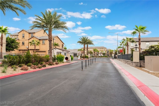 4610 Lime Straight Dr, Las Vegas, NV 89115 - view of asphalt road featuring a residential view, curbs, street lighting, sidewalks, and traffic signs