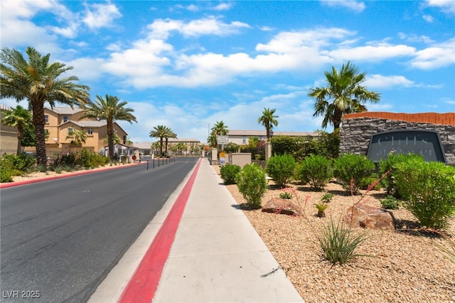 4610 Lime Straight Dr, Las Vegas, NV 89115 - view of asphalt street featuring street lights, sidewalks, curbs, and a gated entry