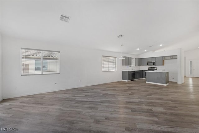2410 Morocco Ave, North Las Vegas, NV 89031 - unfurnished living room with lofted ceiling, wood finished floors, baseboards, and recessed lighting