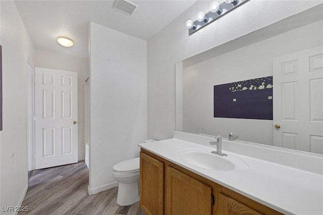 2410 Morocco Ave, North Las Vegas, NV 89031 - bathroom with vanity, wood finished floors, toilet, baseboards, and shower / tub combination