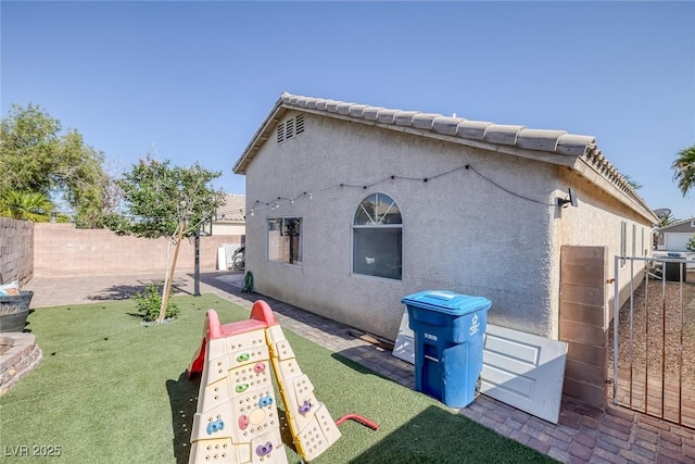 2410 Morocco Ave, North Las Vegas, NV 89031 - rear view of house with a fenced backyard and stucco siding