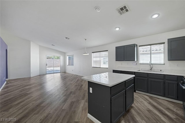 2410 Morocco Ave, North Las Vegas, NV 89031 - kitchen featuring a sink, vaulted ceiling, dark wood-style flooring, a center island, and recessed lighting