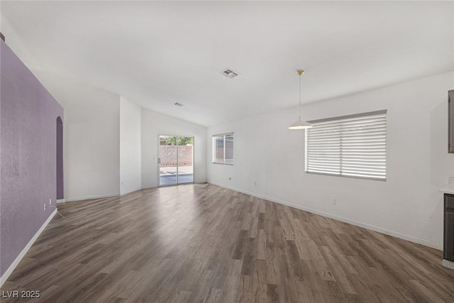 2410 Morocco Ave, North Las Vegas, NV 89031 - unfurnished living room with arched walkways, wood finished floors, baseboards, and lofted ceiling