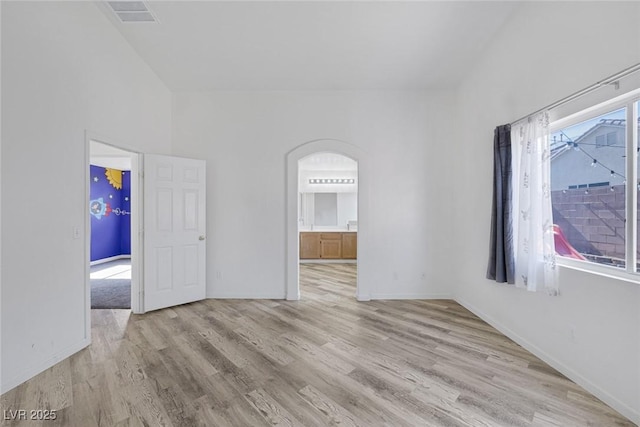 2410 Morocco Ave, North Las Vegas, NV 89031 - unfurnished room with arched walkways, wood finished floors, and baseboards