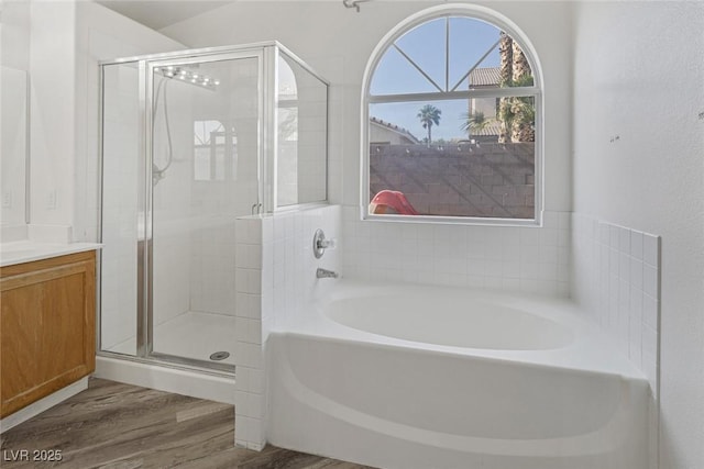 2410 Morocco Ave, North Las Vegas, NV 89031 - bathroom with wood finished floors, a garden tub, a shower stall, and vanity