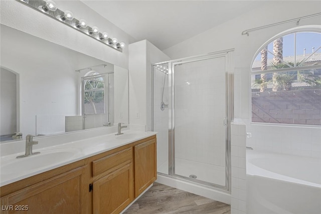 2410 Morocco Ave, North Las Vegas, NV 89031 - bathroom featuring a garden tub, a shower stall, double vanity, and wood finished floors