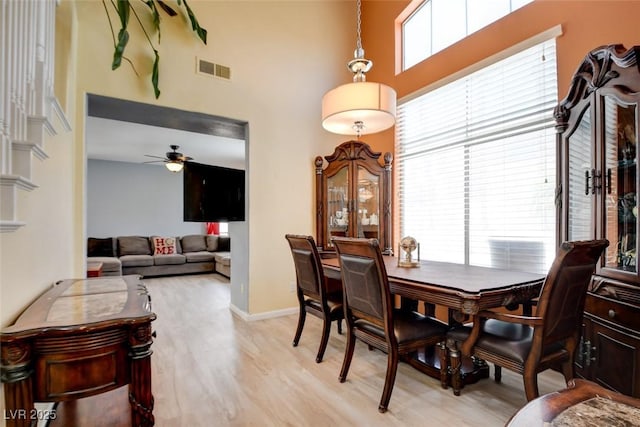 4835 Willow Glen Dr, Las Vegas, NV 89147 - dining room with a high ceiling, ceiling fan, light wood-style floors, and baseboards