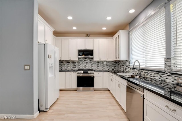 4835 Willow Glen Dr, Las Vegas, NV 89147 - kitchen featuring stainless steel appliances, backsplash, a sink, dark countertops, and recessed lighting