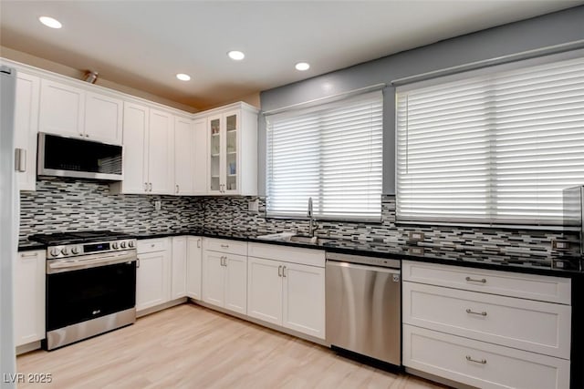 4835 Willow Glen Dr, Las Vegas, NV 89147 - kitchen with stainless steel appliances, dark countertops, a sink, backsplash, and recessed lighting
