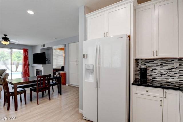 4835 Willow Glen Dr, Las Vegas, NV 89147 - kitchen with white refrigerator with ice dispenser, backsplash, dark countertops, white cabinetry, and ceiling fan