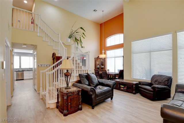 4835 Willow Glen Dr, Las Vegas, NV 89147 - living room featuring a high ceiling, stairway, and light wood-style floors