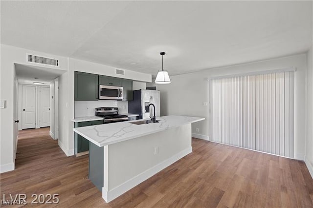 728 Carpenter Dr, Las Vegas, NV 89107 - kitchen with stainless steel appliances, a sink, wood finished floors, and baseboards