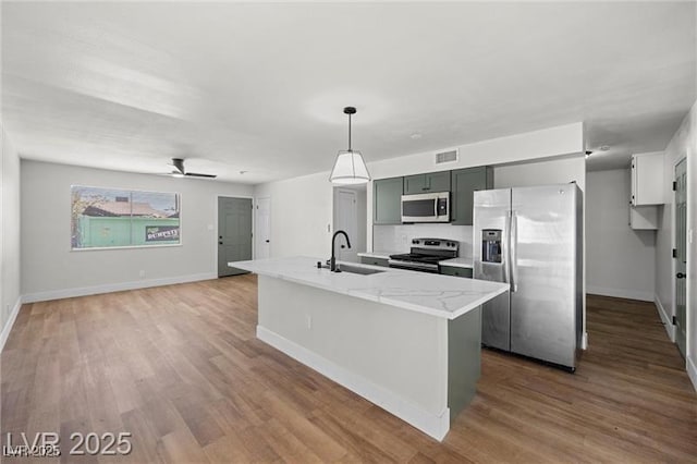 728 Carpenter Dr, Las Vegas, NV 89107 - kitchen with stainless steel appliances, a sink, baseboards, and light wood finished floors