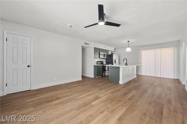 728 Carpenter Dr, Las Vegas, NV 89107 - kitchen with stainless steel appliances, light countertops, a ceiling fan, light wood-style floors, and baseboards