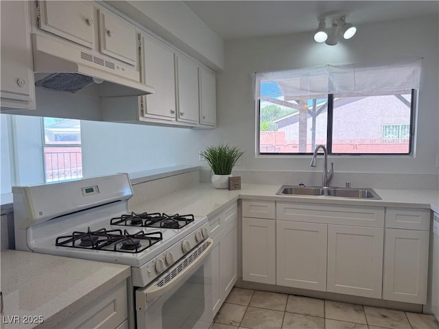5600 Grossmont Ave, Las Vegas, NV 89110 - kitchen with white gas range oven, a sink, under cabinet range hood, and plenty of natural light