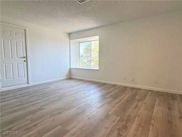 5600 Grossmont Ave, Las Vegas, NV 89110 - empty room with wood finished floors, a textured ceiling, and baseboards