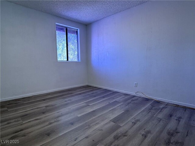 5600 Grossmont Ave, Las Vegas, NV 89110 - spare room with dark wood-style flooring, a textured ceiling, and baseboards