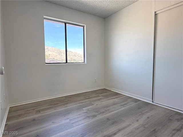 5600 Grossmont Ave, Las Vegas, NV 89110 - spare room with a textured ceiling, wood finished floors, and baseboards