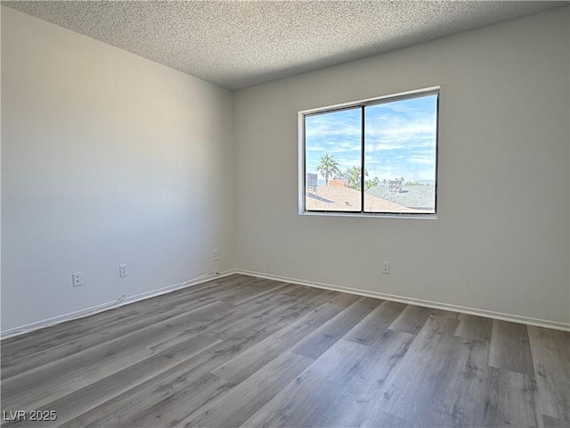 5600 Grossmont Ave, Las Vegas, NV 89110 - empty room featuring dark wood finished floors, a textured ceiling, and baseboards