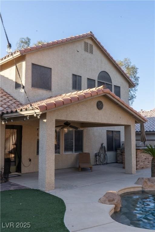 2549 Sundew Ave, Henderson, NV 89052 - back of house with a tile roof, a patio area, stucco siding, and an outdoor pool