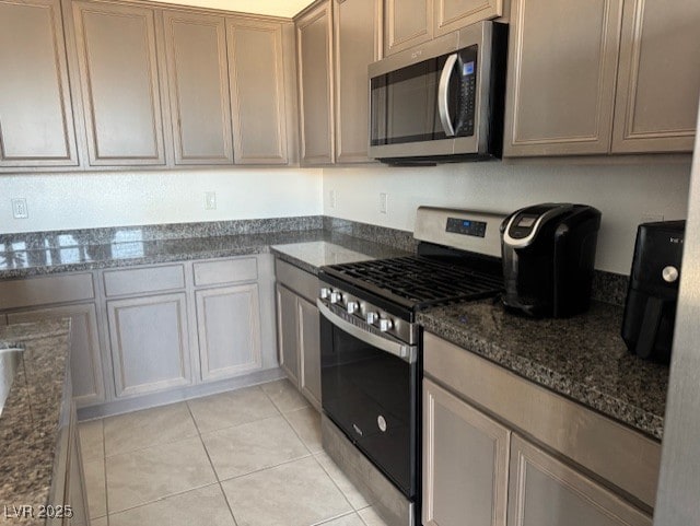 411 Hellebores Ave, North Las Vegas, NV 89084 - kitchen with stainless steel appliances, light tile patterned floors, and dark stone countertops