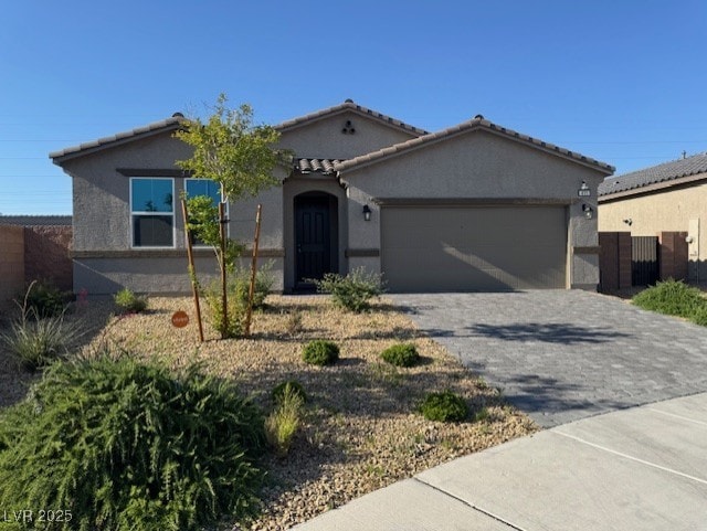 411 Hellebores Ave, North Las Vegas, NV 89084 - view of front of house featuring a garage, decorative driveway, stucco siding, and a tiled roof