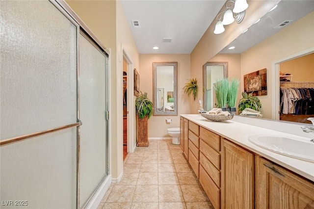 2545 Nashira St, Henderson, NV 89044 - full bathroom with a spacious closet, a stall shower, toilet, double vanity, and tile patterned flooring