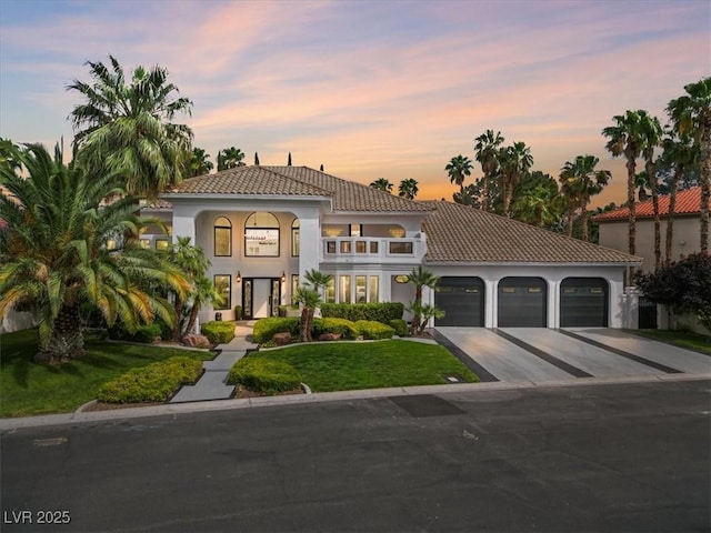 21 Sawgrass Ct, Las Vegas, NV 89113 - mediterranean / spanish-style house featuring a balcony, a garage, driveway, a tile roof, and a front lawn