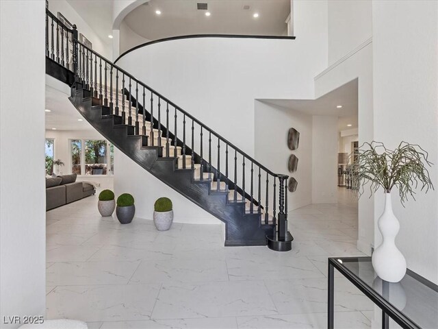21 Sawgrass Ct, Las Vegas, NV 89113 - stairway featuring marble finish floors, a high ceiling, recessed lighting, and arched walkways