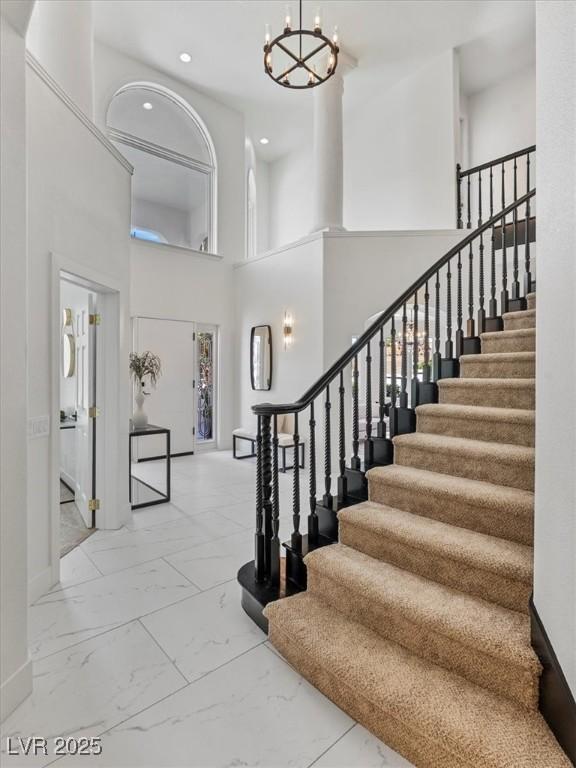 21 Sawgrass Ct, Las Vegas, NV 89113 - entryway featuring marble look tile flooring, a chandelier, a towering ceiling, stairway, and recessed lighting