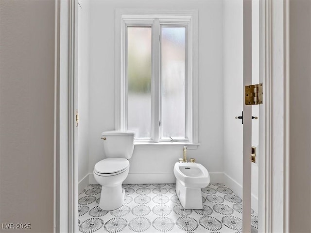 21 Sawgrass Ct, Las Vegas, NV 89113 - bathroom featuring a bidet, toilet, plenty of natural light, and baseboards