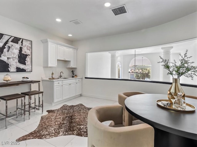 21 Sawgrass Ct, Las Vegas, NV 89113 - kitchen featuring a sink, light marble finish floors, recessed lighting, white cabinetry, and baseboards