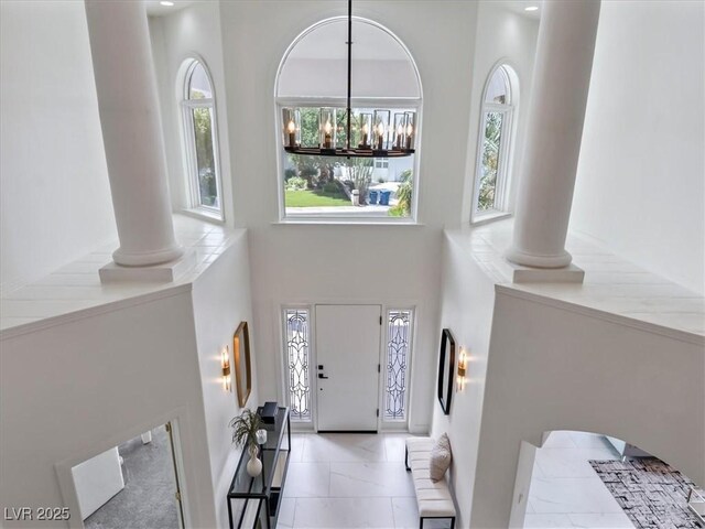 21 Sawgrass Ct, Las Vegas, NV 89113 - foyer entrance with ornate columns, plenty of natural light, a towering ceiling, a chandelier, and baseboards