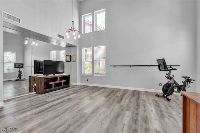 9585 Teton Diablo Ave, Las Vegas, NV 89117 - workout room with a chandelier, wood finished floors, baseboards, and a towering ceiling