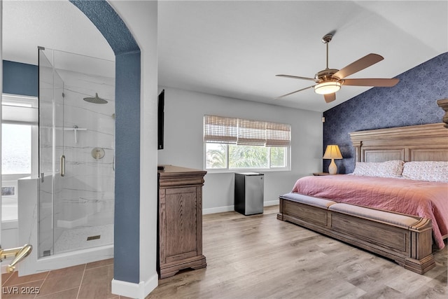 9585 Teton Diablo Ave, Las Vegas, NV 89117 - bedroom with baseboards, arched walkways, wallpapered walls, ceiling fan, and ensuite bath
