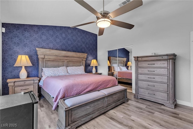 9585 Teton Diablo Ave, Las Vegas, NV 89117 - bedroom with an accent wall, wallpapered walls, light wood-type flooring, baseboards, and ceiling fan