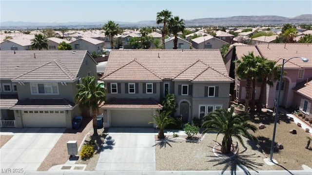 9585 Teton Diablo Ave, Las Vegas, NV 89117 - mediterranean / spanish house with a residential view, an attached garage, concrete driveway, and a tiled roof