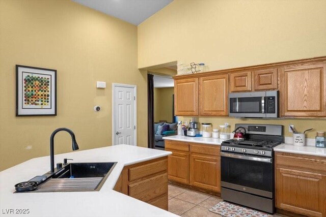 4308 Brazil Palm Ct, North Las Vegas, NV 89032 - kitchen with stainless steel appliances, a high ceiling, light countertops, a sink, and light tile patterned flooring