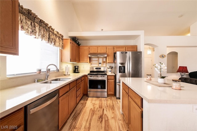 945 Stetson Dr, Henderson, NV 89002 - kitchen with stainless steel appliances, a sink, light wood-type flooring, light countertops, and under cabinet range hood